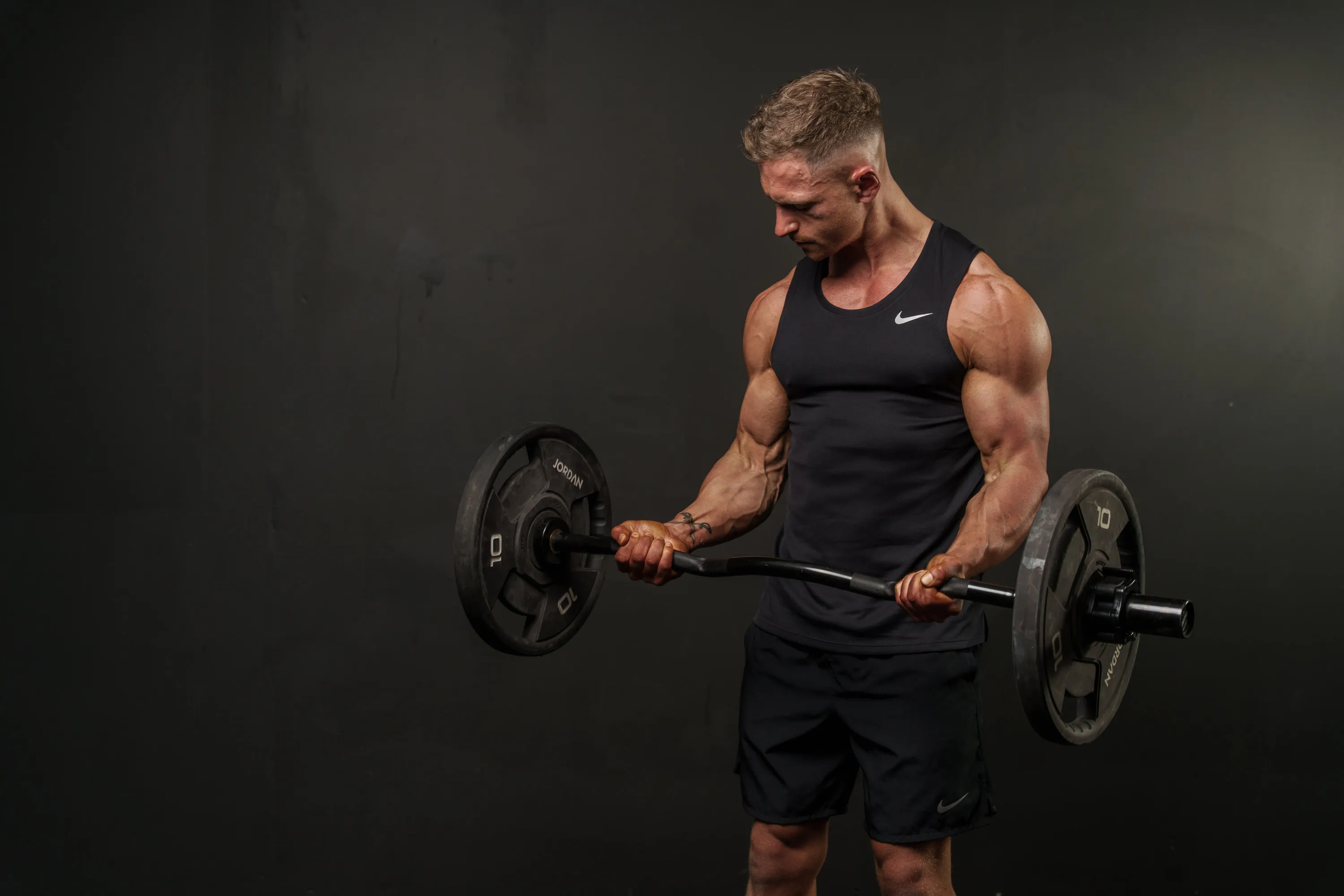 Callum Gilbert doing a barbell curl in the gym